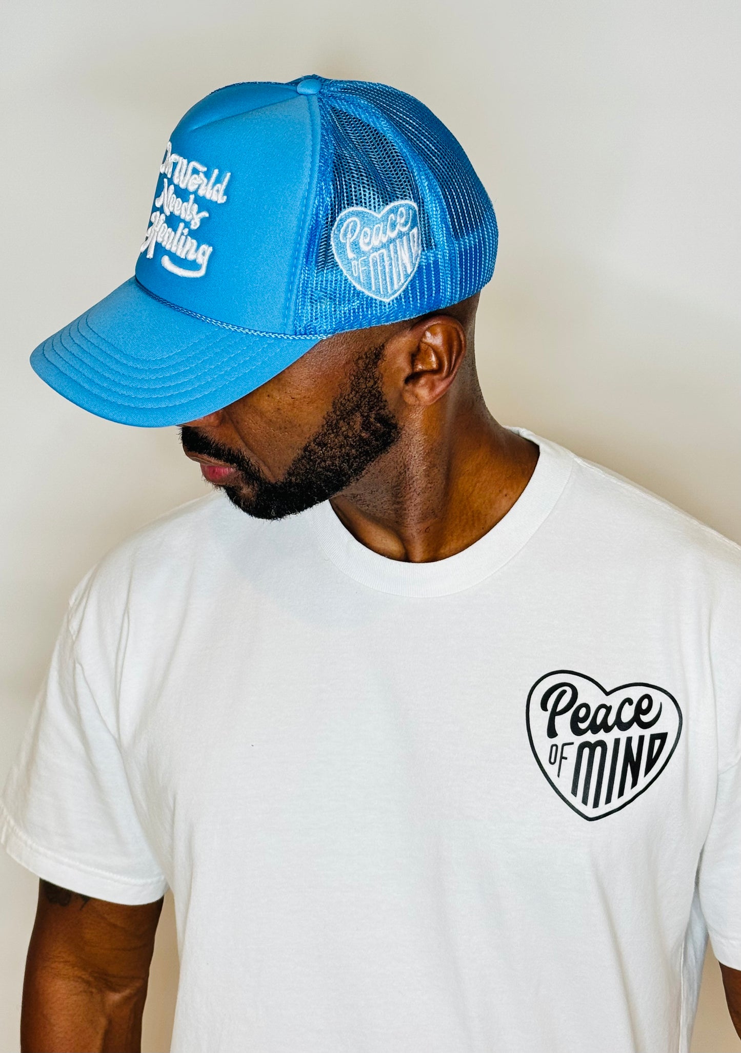 World Needs Healing Trucker Hat Carolina Blue