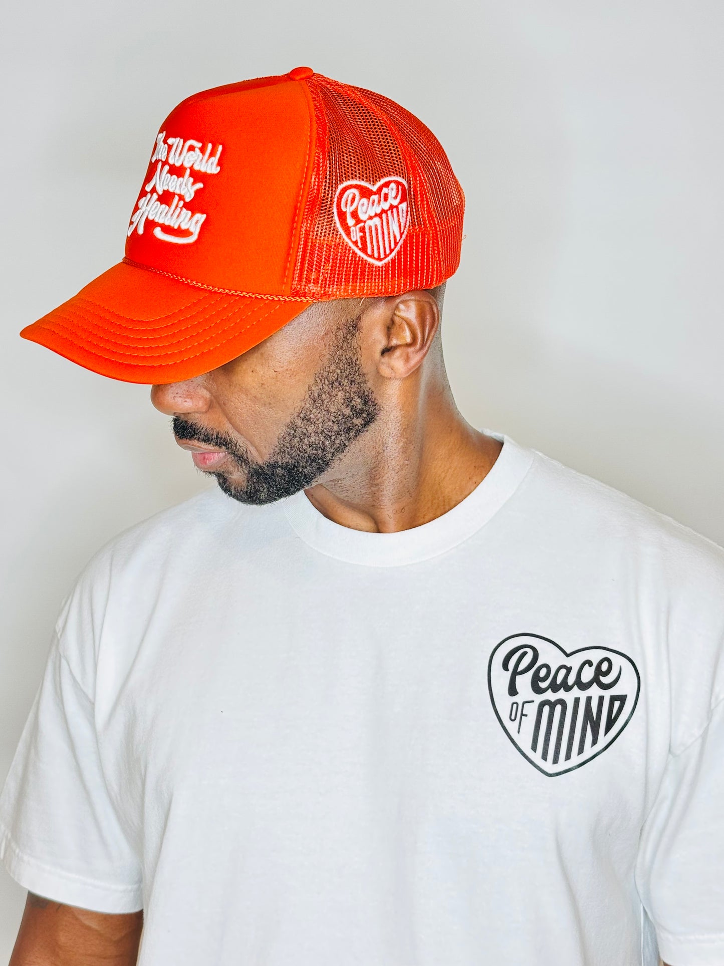 World Needs Healing Trucker Hat Orange