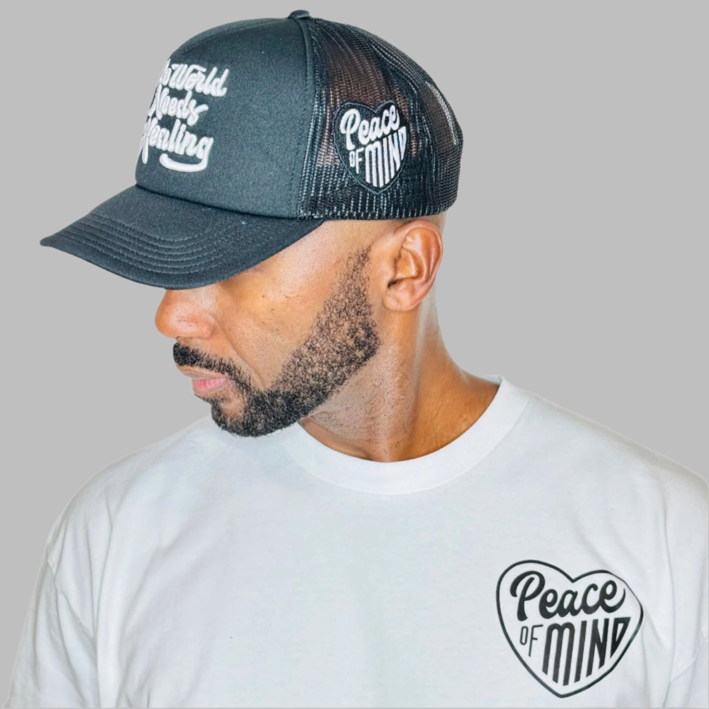 World Needs Healing Trucker Hat Black