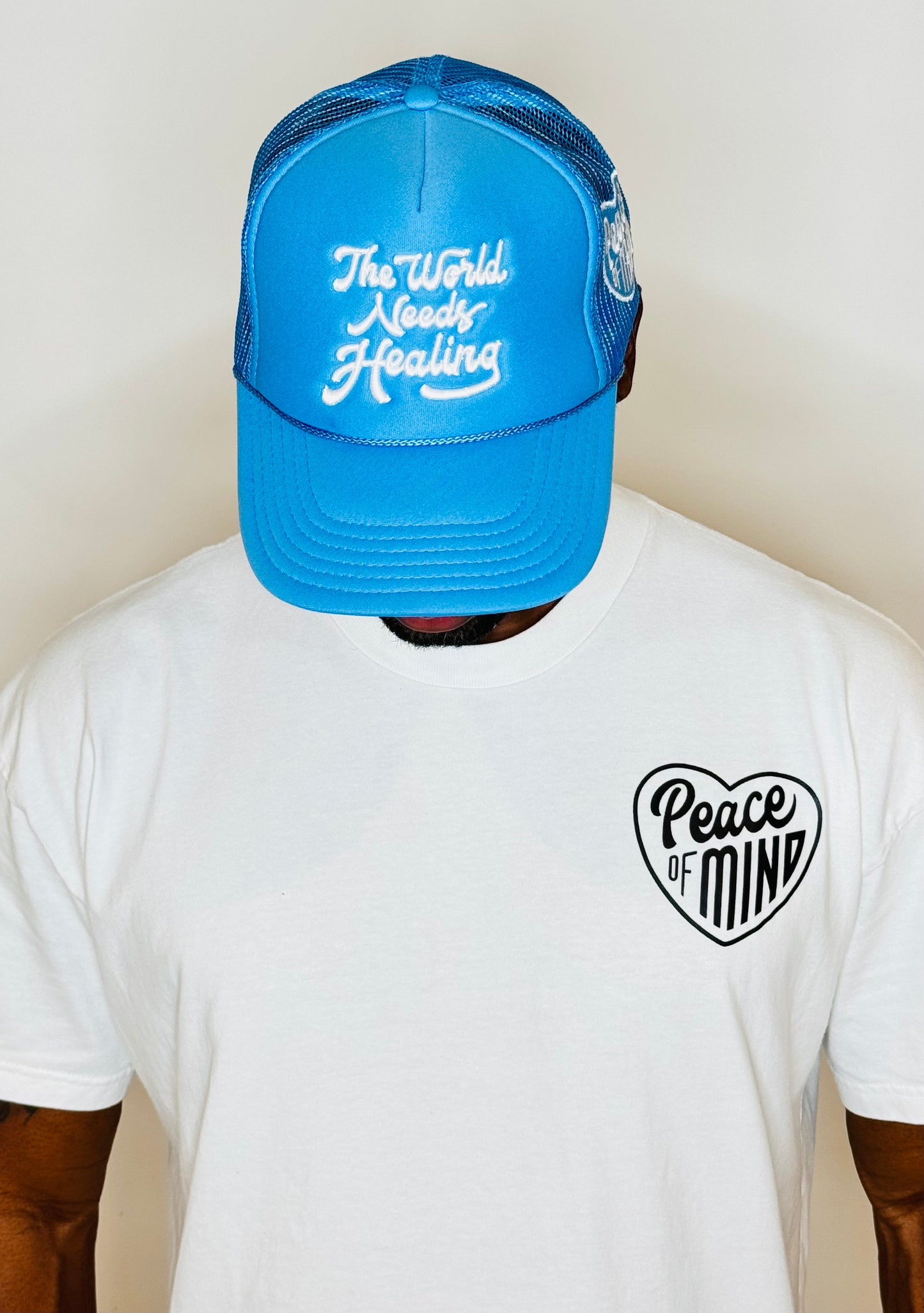 World Needs Healing Trucker Hat Carolina Blue